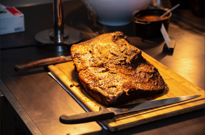 an image of a brisket under a hot light with an orange glow