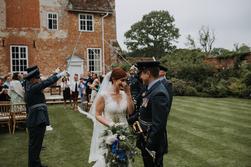 A bride and groom being welcomed by wedding guests.