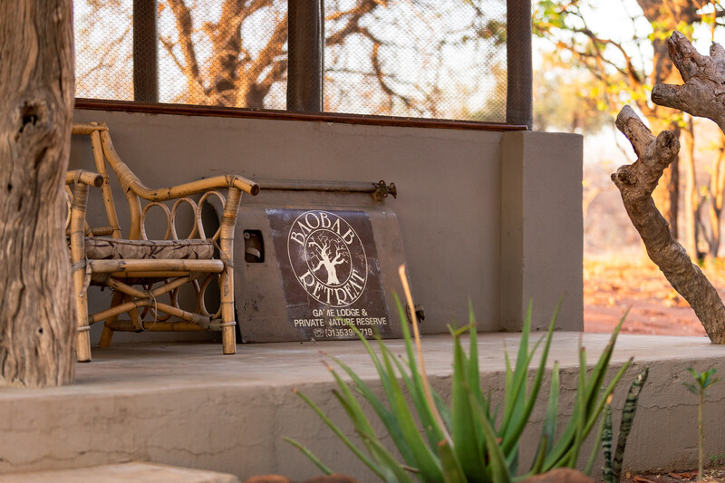 Low shot of the exterior of an African style building with the logo of the retreat on the old door of a truck.