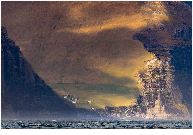 The village of Mikladalur on Kalsoy (Faroe Islands) from a large distance shows how impressive the mountains are compared with the settlement. The subject are the houses of the village. (EOS 5D mark IV + EF100-400L @ 263mm (+ crop) | ISO100 | f/8 | 1/400)