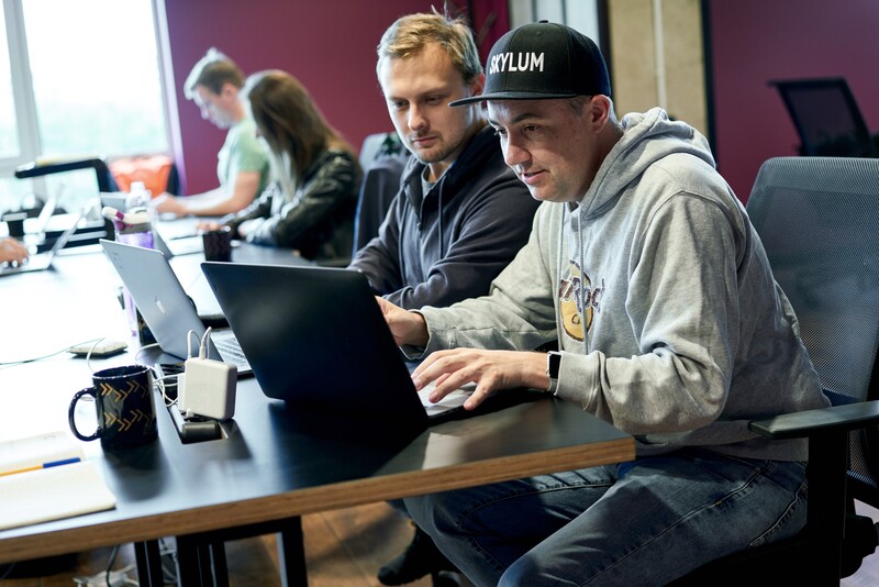 Two Skylum employees working on their laptops at a desk