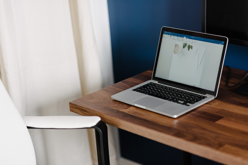 A laptop on a wooden desk. 