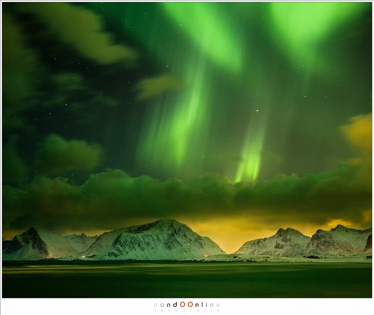 Clouds may obscure the polar lights, but they also light up by the artificial city lights, giving the landscape a terrible yellow color cast. On the other hand, it also provides a nice contrast with the green curtains in the sky (EOS 1Dx + 45mm | ISO6400 