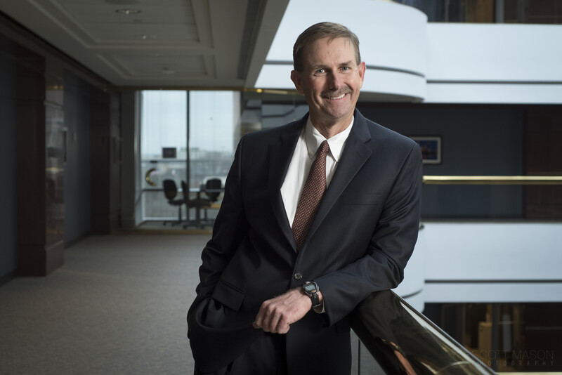 an executive portrait of a man in a suit, smiling