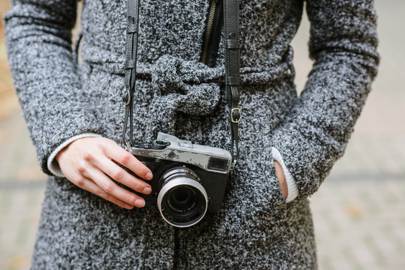 A Fuji mirrorless with a black leather camera strap