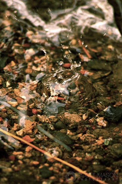 a water droplet splashing over rocks