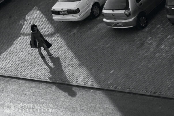 a view from above of a woman walking down a brick sidewalk