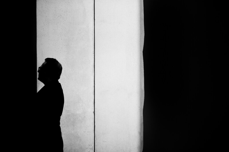 A silhouette of a man by a wall
