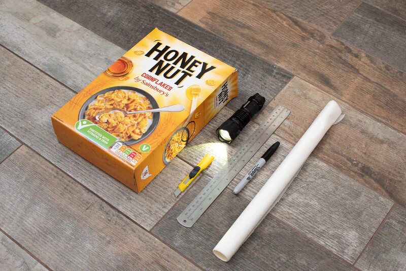 Image shows materials required for making the light table. This includes a cereal box, torch, tracing paper, a pen, a knife and a ruler