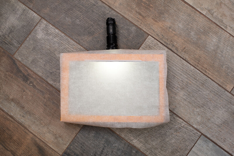 Place tracing paper over the cut hole in the box and put the torch through the side