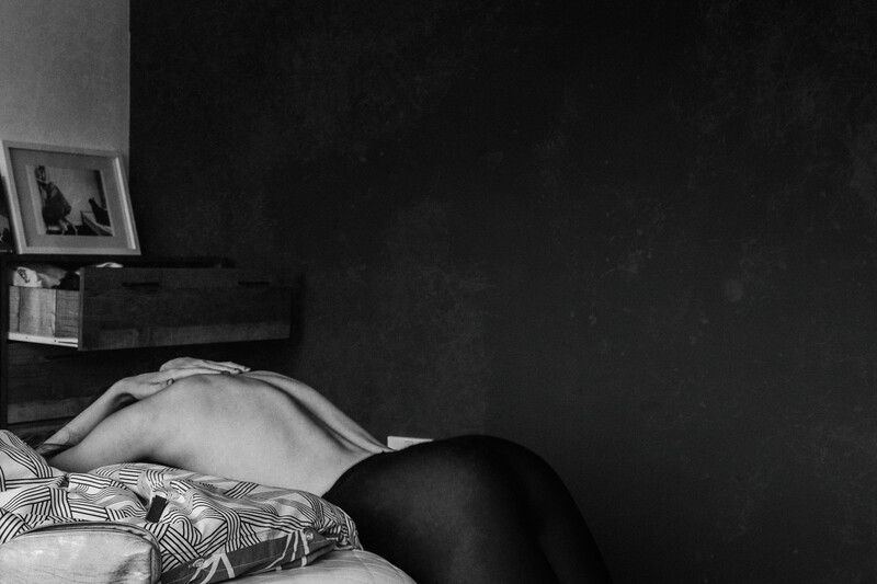 An implied nude of a woman laying on the bed.