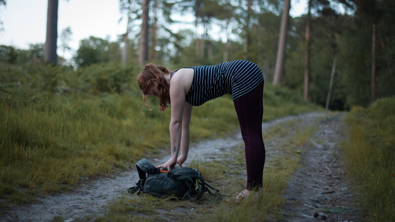 Extend your spine with a forward bend and a camera bag