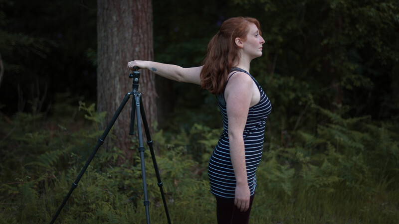 Kat Bayly doing a photography stretch with a tripod