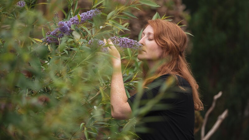 Woman smelling buddleia flower