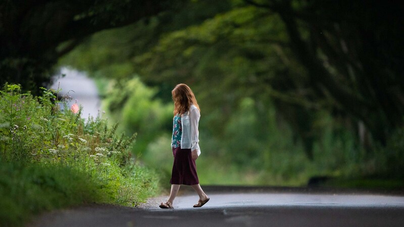 Woman walking along road