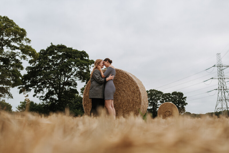 Two young women having a photoshoot in a field.