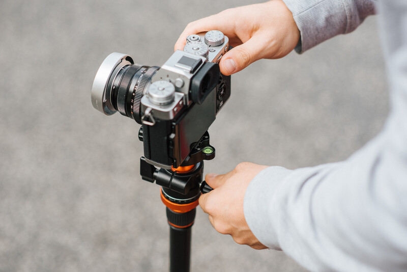 A man using camera on a tripod.