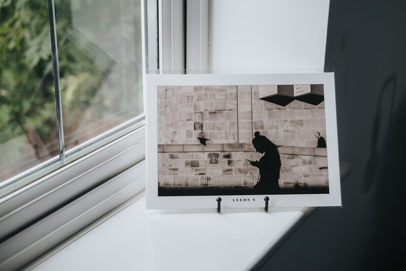 A printed photograph in a black display on a windowsill.