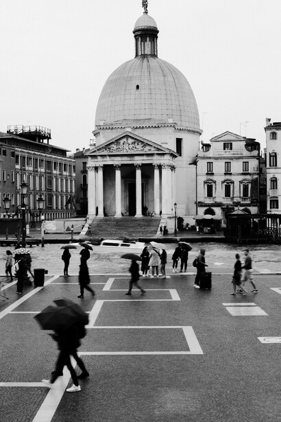 People walking by on a street in Venice.