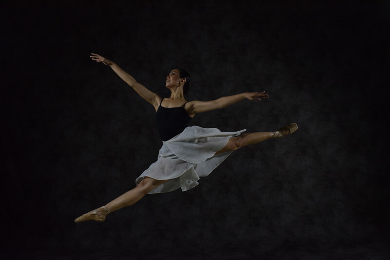 A ballerina dancing and jumping up in the air.