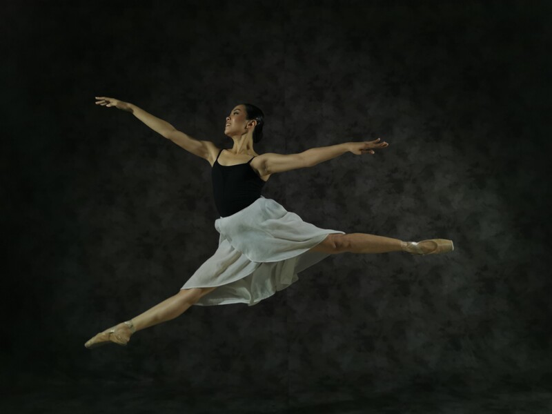 A ballerina dancing and jumping in the air. 
