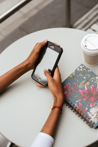 A girl using a phone at a cafe.