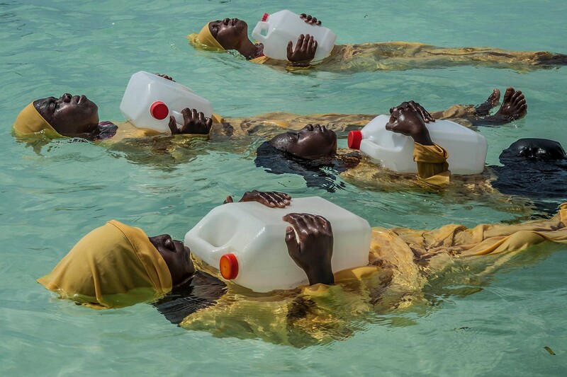 Young women learning to swim on their backs.