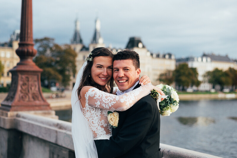 A bride and groom on a bridge.