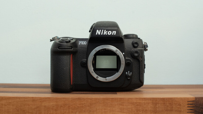 Film camera Nikon F100 on wood