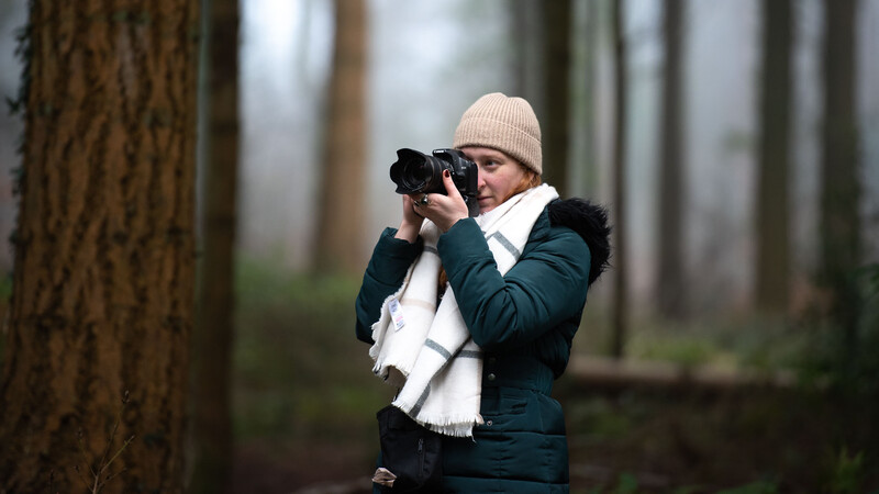 Woman with camera in forest