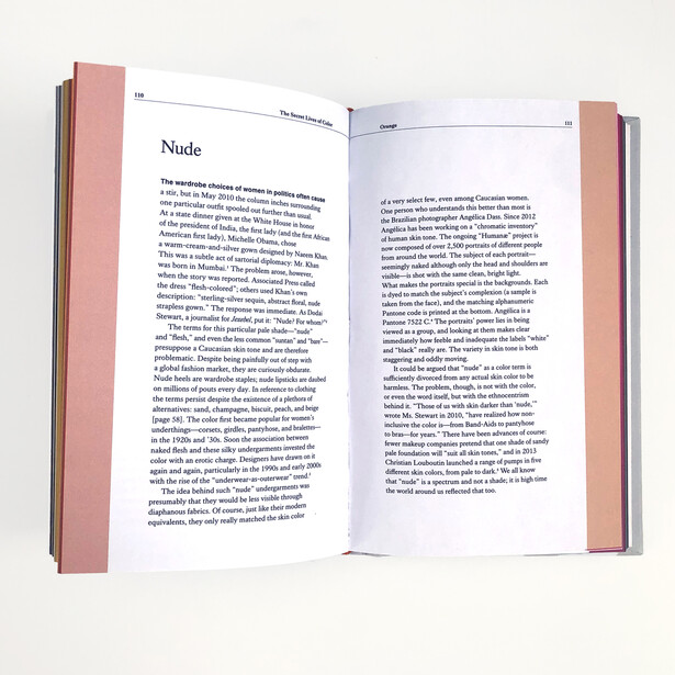 Open book with pink cloth covers displaying a page titled 'Nude' with dense body text in a serif typeface.