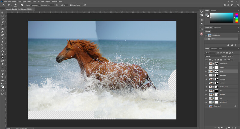 Brown horse running through ocean waves with water splashing around its legs.