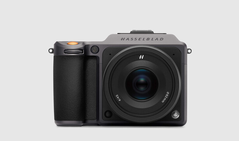 Hasselblad medium format camera with integrated grip and fixed lens on neutral background.
