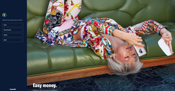 Person in colorful patterned clothing reclined on green leather sofa holding cash.