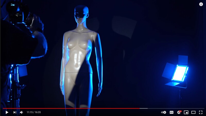 Studio lighting setup with mannequin illuminated by blue LED panels and key light.