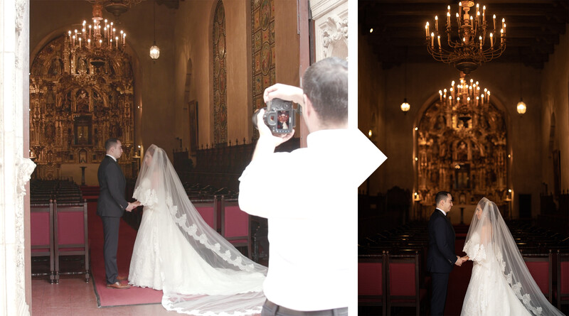Bride and groom at altar in ornate church during wedding ceremony with elaborate chandeliers.