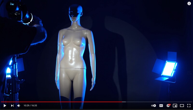Studio lighting setup with mannequin illuminated by blue LED panels and rim lighting against dark background.