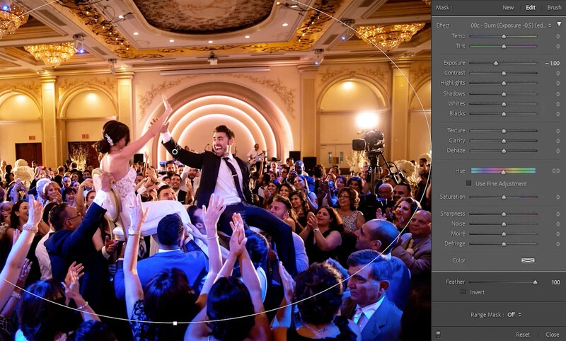 Bride and groom dancing on shoulders of wedding guests in ornate ballroom with golden architecture.