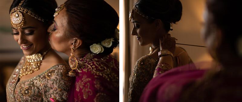 Bride in ornate gold embroidered wedding attire with jewelry being embraced by family members during pre-wedding preparations.