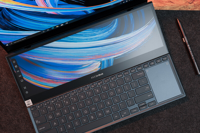 Laptop and tablet displaying matching blue and pink gradient abstract artwork side by side on dark surface.