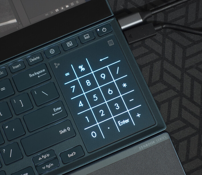 Numeric keypad overlay displayed on a laptop keyboard with a dark geometric patterned surface visible beside it.