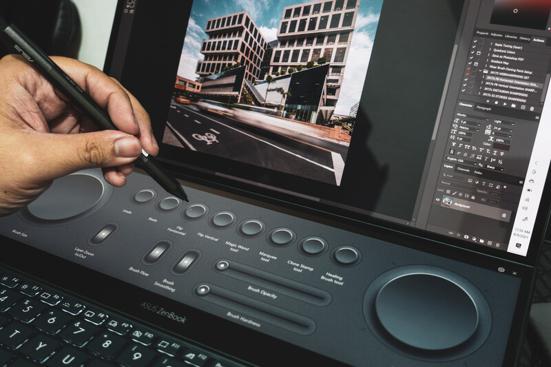 Creative professional using a stylus on a graphics tablet while editing architectural photography on a monitor.