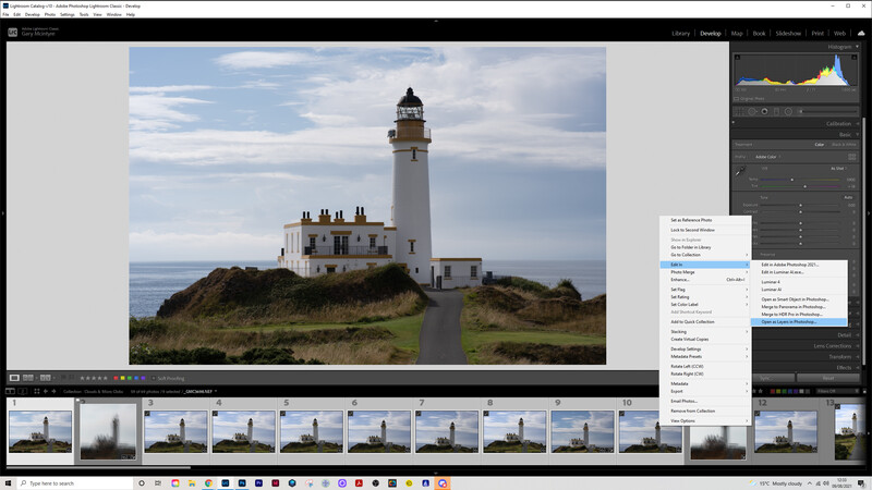 Lighthouse on a grassy headland overlooking the sea under a partly cloudy sky.