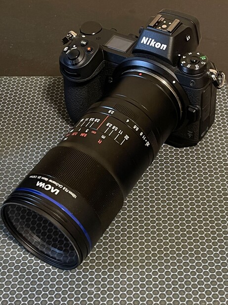 Nikon Z mirrorless camera with Laowa lens mounted on textured gray surface.