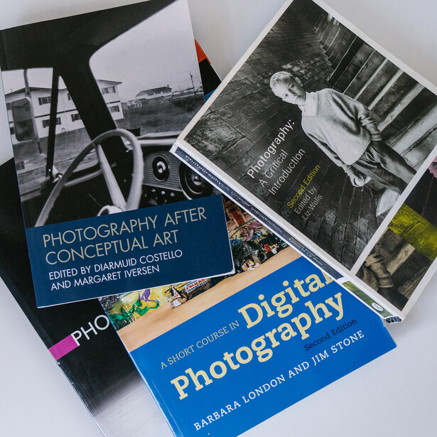 Three photography books arranged on a white surface, including titles about conceptual art and digital photography.