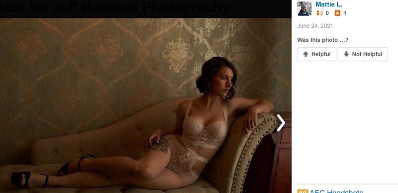 Woman in beige lingerie reclining on an upholstered sofa against damask wallpaper.