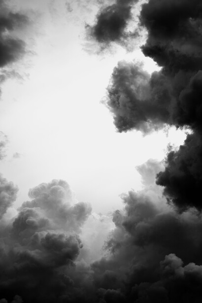 Dramatic black and white sky filled with layered storm clouds creating strong tonal contrast.