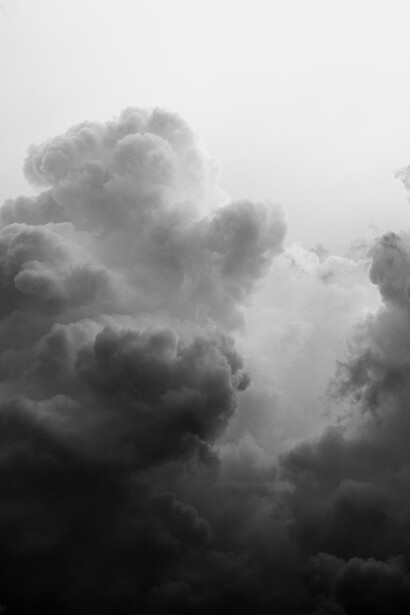 Towering storm clouds with dramatic dark and light contrasts captured in monochrome.