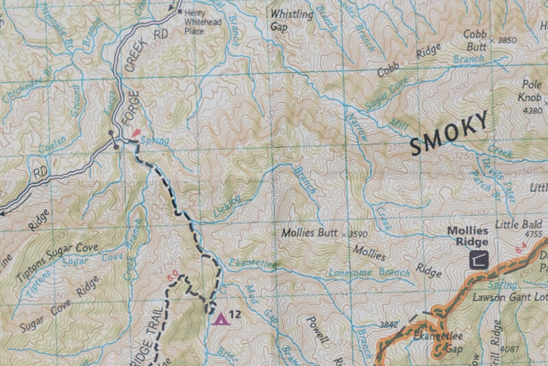 Topographic map showing a hiking trail route marked with black dashed lines through mountainous terrain near the Smoky Mountains.