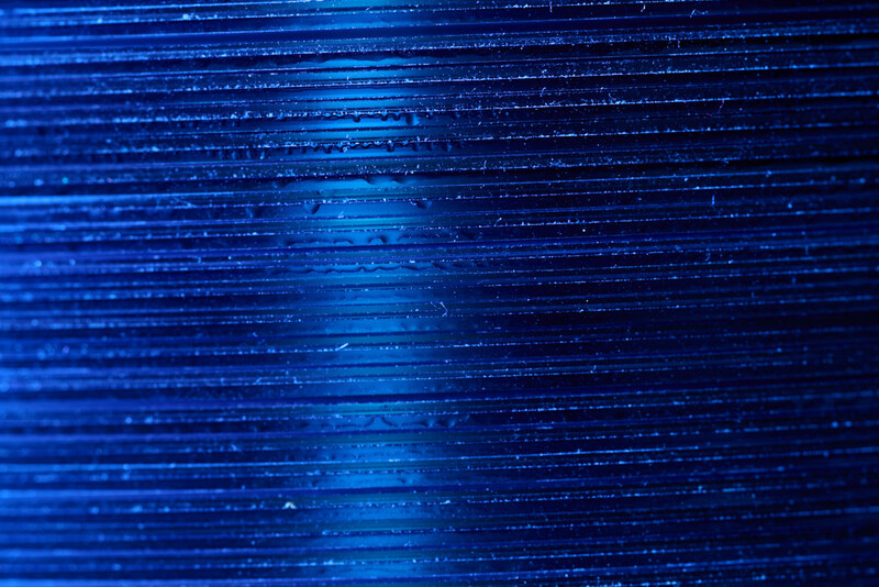 Abstract blue digital lines and particles flowing diagonally across a dark background.